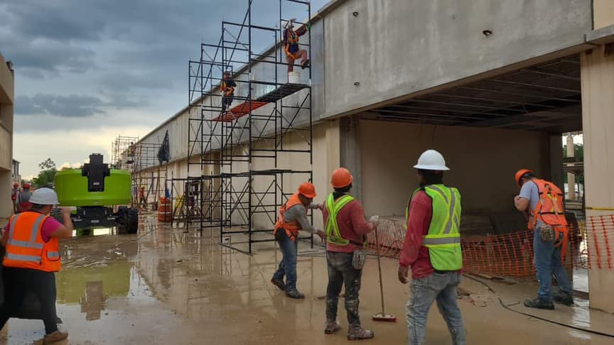 Obra en ejecución con andamios y personal con equipo de protección